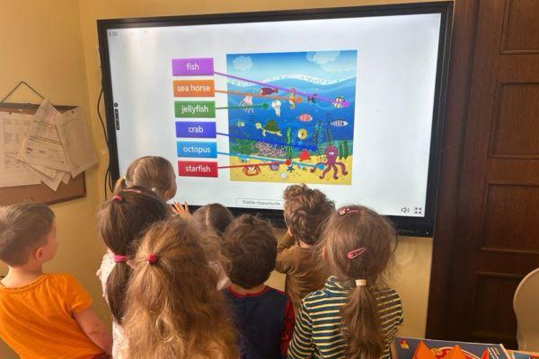 Copii folosind tabla interactivă la Academia Viitorilor Exploratori